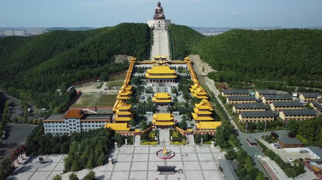 Aerial view of the Golden Buddha statue at Liudingshan Cultural Tourism Area in Dunhua City, Jilin Province, China. Massive golden statue overlooking Zhengjue Temple and facing the Changbai Mountain