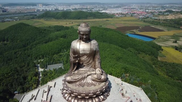 Aerial view of the Golden Buddha statue at Liudingshan Cultural Tourism Area in Dunhua City, Jilin Province, China. Massive golden statue overlooking Zhengjue Temple and facing the Changbai Mountain
