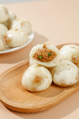 Fresh Steamed Chinese Pork Buns with Meat Filling on Wooden Plate - Traditional Asian Breakfast Cuisine