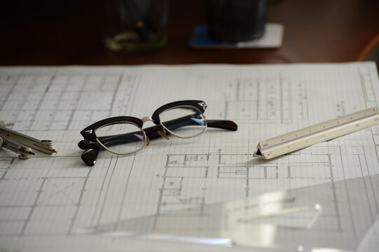 建築士の製図机に置かれた眼鏡と製図道具 Architect&rsquo;s drafting desk with glasses and drawing tools
