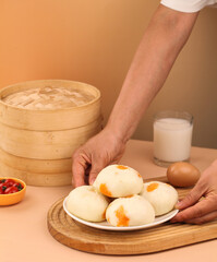 Traditional Chinese Xiaolongbao Steamed Buns with Orange Filling and Bamboo Steamer Setup
