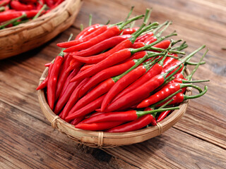 Freshly Picked Red Chili Peppers from Sichuan Farms in Woven Basket on Wooden Table