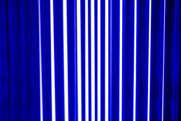 An abstract, vibrant blue background featuring parallel, vertical columns of intense light, suggesting digital data flow or energetic lines