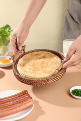 Handmade Crepes in Wicker Basket with Sausages - Traditional Home Cooking Scene
