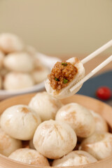Traditional Xiao Long Bao Soup Dumplings from Shengzhou China Being Dunked with Chopsticks