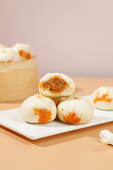 Traditional Chinese Xiaolongbao Steamed Buns with Golden Egg Yolk Filling on White Plate