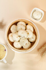 Traditional Xiaolongbao Pork Soup Dumplings in Bamboo Steamer with Tea and Dipping Sauce