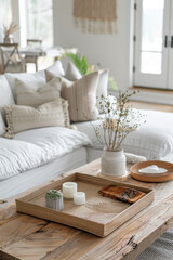 Fototapeta premium Cozy living room vignette with textured pillows, natural wood coffee table, and decorative tray featuring candles and plant