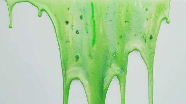 Vibrant green slime dripping down from the top against a white background.