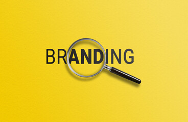 A magnifying glass focuses on BRANDING against a yellow background 