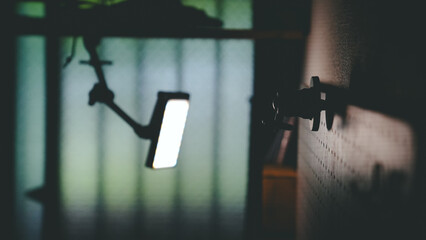 Bright LED Video Light Shining in a Dark Studio or Workspace - Cinematic Silhouette / 暗いスタジオや作業空間で輝くLEDビデオライト