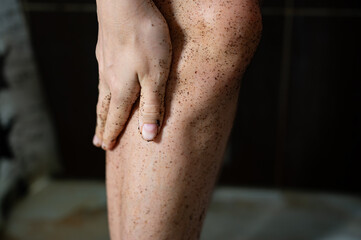 Fototapeta premium Coffee body scrub on female legs