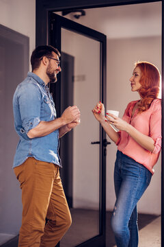 Cheerful office workers relaxing on a coffee break and chatting together.