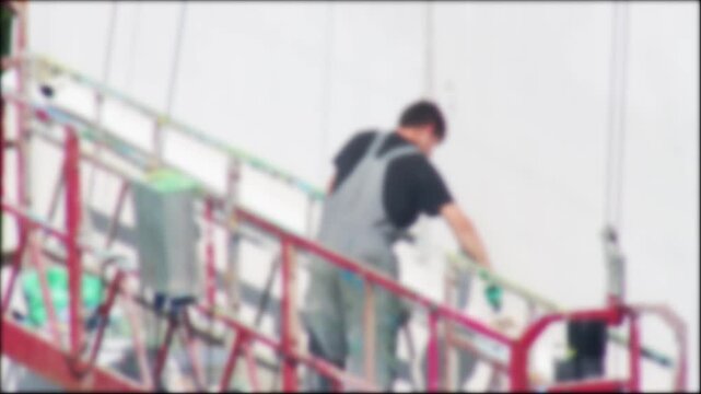 Blurred Background Of Industrial Painter On Suspended Lift. Defocused Man In Overalls Renovates Building Exterior With White Paint.