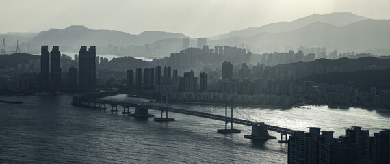 Busan skyline with mountains and Gwangandaegyo Bridge reflecting light on ocean