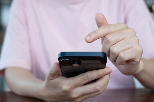 Close-up of a person using a smartphone with one hand tapping on the screen, representing communication, technology, social media, and modern digital lifestyle concepts. - Powered by Adobe