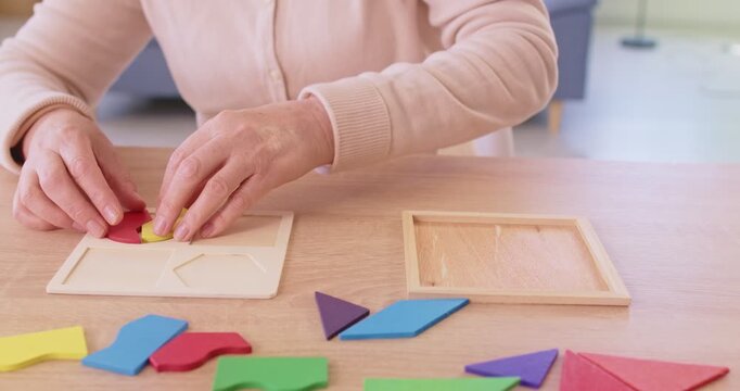 Senior elderly female engaged in logic game, playing for developing memory, learning to plan strategy game, anti dementia, brain disorder, causing thinking ability, cognitive decline symptoms 