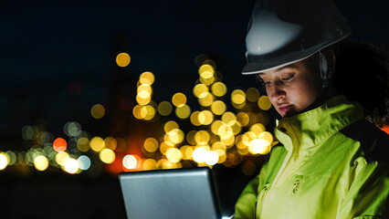 An energy professional ensures continuous 24 7 operations at a refinery. She uses digital technology to monitor sustainable production during the night shift.