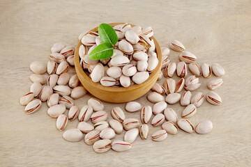 Pistachios spilled out of wooden bowl, close up