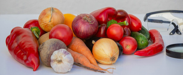 Microscope, test tubes, and fresh vegetables on a lab table for nutritional research