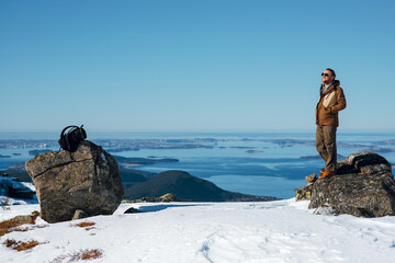Man on Snowy Mountain Overlooking Ocean