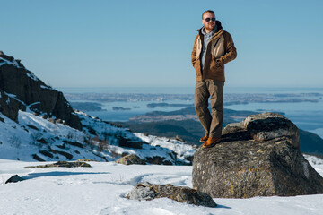 Man Standing on Rock in Snowy Mountain Landscape