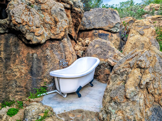 Traditional vintage bathtub nestled among rocks. Outdoor bathing area in nature, lakes in the Waterberg region, Namibia, Africa.