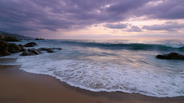 Dramatic twilight sky over a serene beach with waves and rocky shore