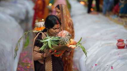 In Bihar, women perform the Chhath Puja ritual at sunrise, holding bamboo baskets filled with fruits and lamps, offering them to the Sun God with pure devotion and prayers for family well-being.
