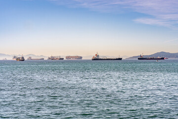 Obraz premium Cargo Ships Anchored across the Gibraltar bay with a misty African coast in the back ground