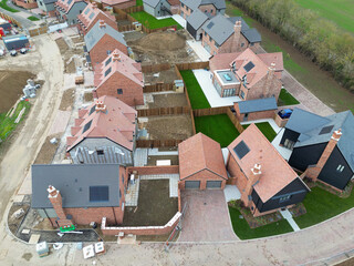 Aerial view of a near completed British housing estate of both first time and detached luxury family homes. Top soil can be seen laid to some of the houses back gardens.