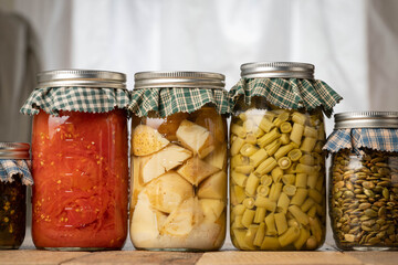 Food harvested and preserved by canning in glass jars.  Potatoes, tomatoes, beans, salsa, and pumpkin seeds.