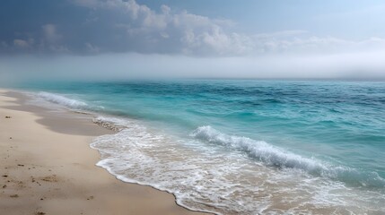 Misty turquoise ocean waves roll onto a serene white sand beach under a dramatic cloudy sky