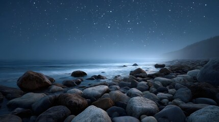 A tranquil misty coastline at night with countless stars visible in the dark sky above a rocky shore and gentle ocean waves