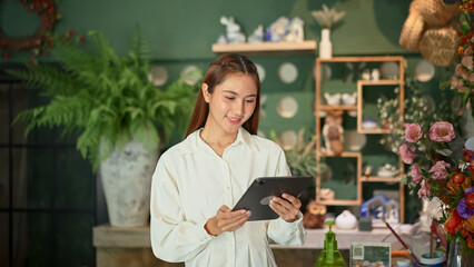 Florist woman business owner managing flower stock with a digital tablet