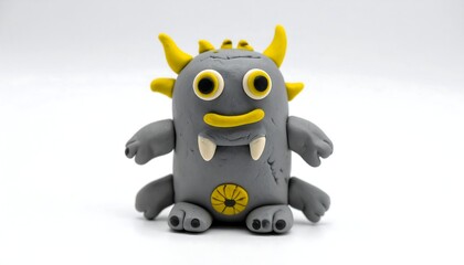 Cute clay monster figurine, gray with yellow horns, eyes, and details, on a plain white background