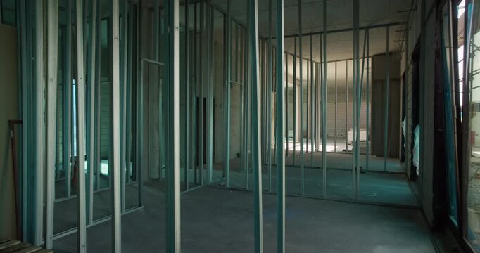Metal stud framing installed for interior partition walls inside a building under construction, showing structure before drywall installation.