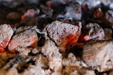 Close-up photo of hot embers and glowing charcoal briquettes radiating intense heat. Roasting....