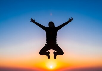 Silhouette of person jumping with arms wide open against a colorful sunrise or sunset sky, symbolizing freedom, success, and happiness.