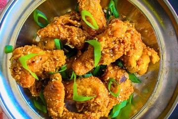 Crispy golden fried chicken wings with fresh green scallions