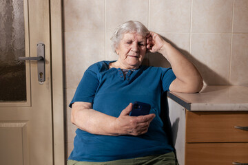 Elderly woman feeling lonely using smartphone at home
