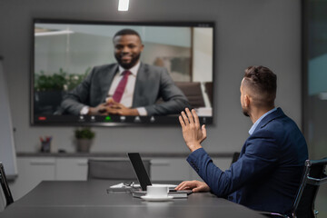 Young middle eastern businessman participates in a video conference with his african american partner.