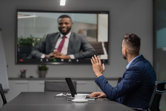 Young middle eastern businessman participates in a video conference with his african american partner.