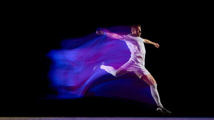 Football player midair kick captured with vibrant motion blur. Concept of dynamic energy, elite performance, and design visuals for sports advertising and motion graphics.