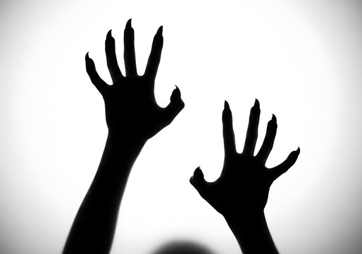 Dark Shadowy Hands Reaching Up with Sharp Claws in a Spooky Horror Scene