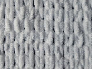 full frame top view of white plush chunky knitted fabric texture background