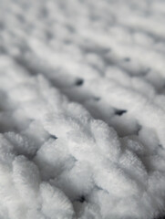 extreme close up of a soft white chunky knitted blanket texture background with selective focus