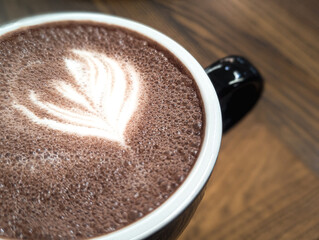 hot cocoa drink with foam art on wooden table close up