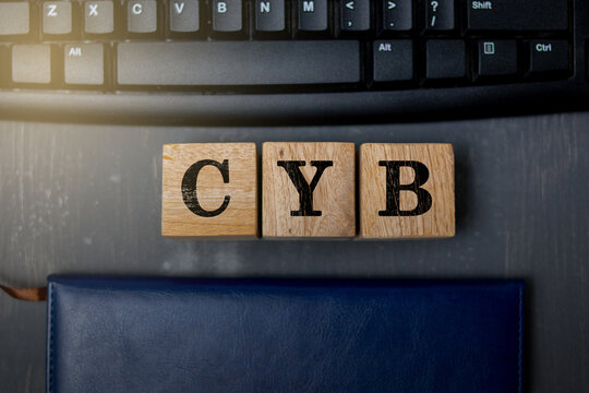 Wooden blocks with letters "CYB" placed on a black computer keyboard, symbolizing cyber technology, internet security, and digital communication in a modern technology concept. - Powered by Adobe