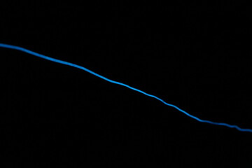 Minimalist abstract background with a single glowing blue neon line on a pure black backdrop. Simple futuristic design element. Blue laser abstract matrix background 